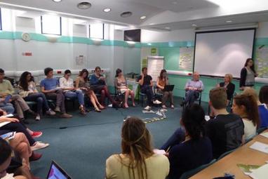 Image of the event with attendants in a room sat in a circle