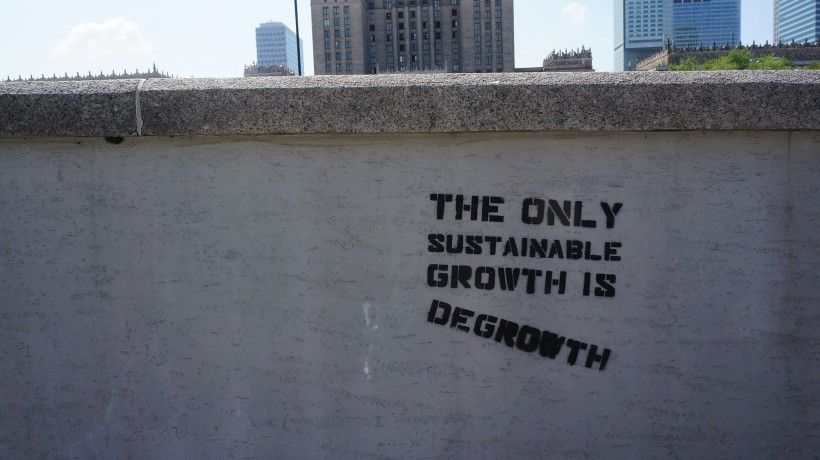 Image of a wall with graffiti saying the only sustainable growth is degrowth